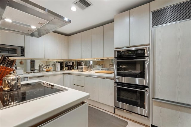 kitchen with extractor fan, a sink, visible vents, light countertops, and appliances with stainless steel finishes