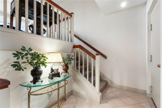 stairs with baseboards and tile patterned floors