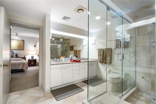 ensuite bathroom with visible vents, connected bathroom, vanity, a shower stall, and tile patterned floors