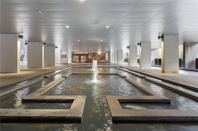 interior space featuring a pool with connected hot tub