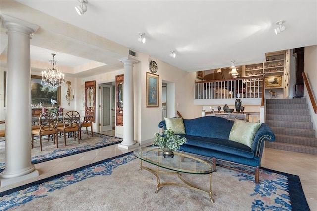 tiled living area with a raised ceiling, visible vents, decorative columns, and stairs