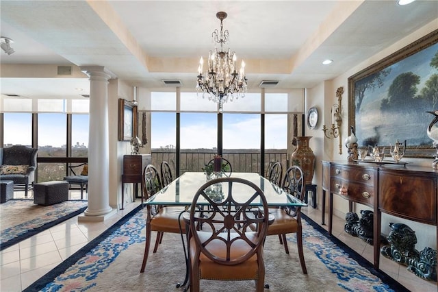 tiled dining room with visible vents, a raised ceiling, decorative columns, and floor to ceiling windows