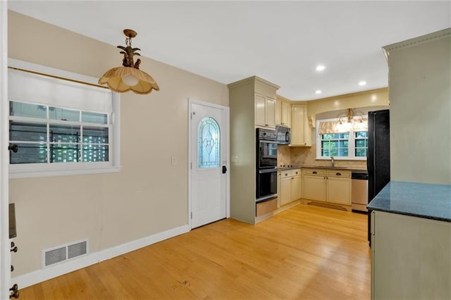 1618 Mason Mill Rd NE, Atlanta, GA 30329 - kitchen featuring black appliances, light wood-style floors, tasteful backsplash, dark countertops, and pendant lighting
