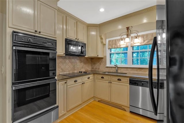1618 Mason Mill Rd NE, Atlanta, GA 30329 - kitchen featuring black appliances, cream cabinetry, tasteful backsplash, and light wood-type flooring