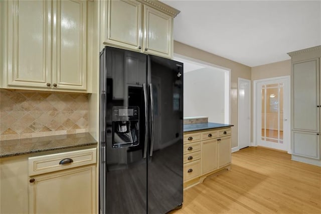 1618 Mason Mill Rd NE, Atlanta, GA 30329 - kitchen with black fridge, cream cabinets, decorative backsplash, light wood-style floors, and dark stone counters