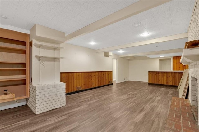 1618 Mason Mill Rd NE, Atlanta, GA 30329 - unfurnished living room featuring wooden walls, wood finished floors, a brick fireplace, wainscoting, and beam ceiling