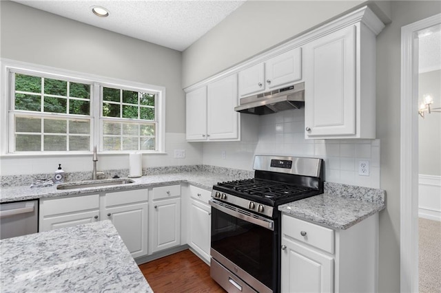 7000 Foxberry Ln, Roswell, GA 30075 - kitchen with appliances with stainless steel finishes, under cabinet range hood, white cabinets, tasteful backsplash, and a textured ceiling