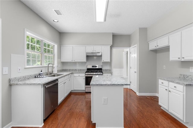 7000 Foxberry Ln, Roswell, GA 30075 - kitchen with stainless steel appliances, dark wood-style flooring, a textured ceiling, and white cabinetry