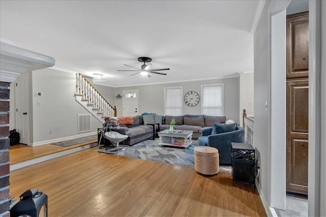 living room featuring wood-type flooring, ceiling fan, and crown molding