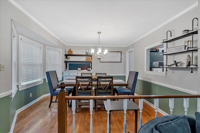 dining area featuring ornamental molding, a chandelier, and light wood-type flooring