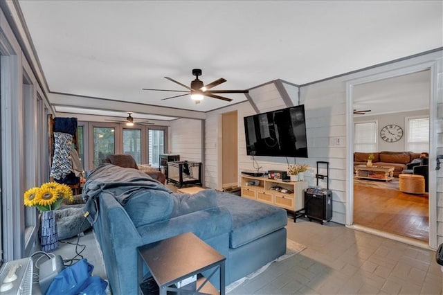 living room with ceiling fan and ornamental molding