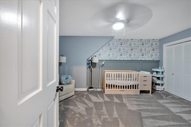 bedroom with ceiling fan, a closet, carpet, and a nursery area