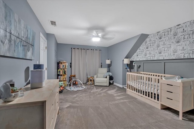 bedroom featuring a crib, carpet floors, and ceiling fan