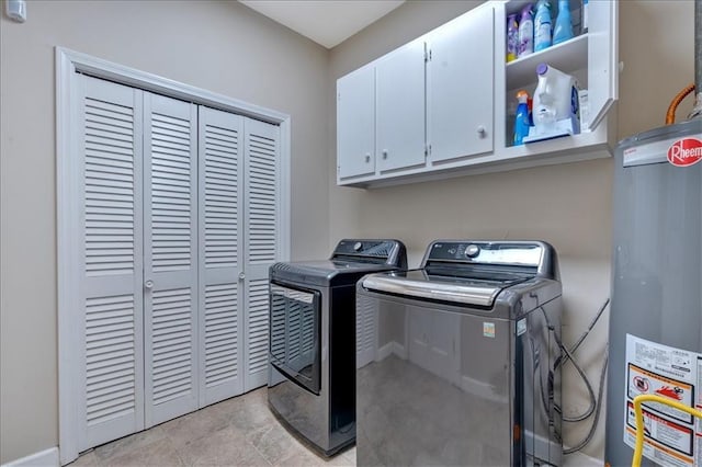 laundry area with washing machine and clothes dryer, cabinets, and gas water heater