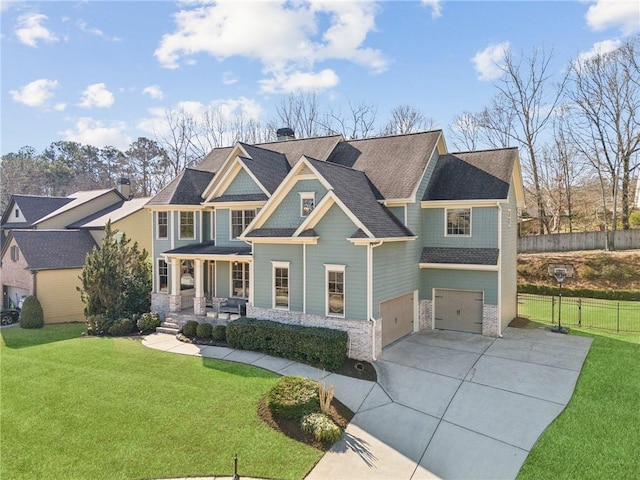 view of front of house featuring driveway, an attached garage, covered porch, fence, and a front lawn