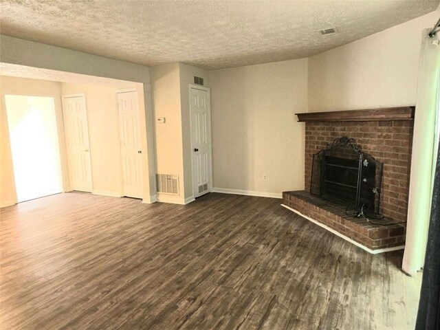 unfurnished living room featuring wood finished floors, a fireplace, a textured ceiling, and baseboards