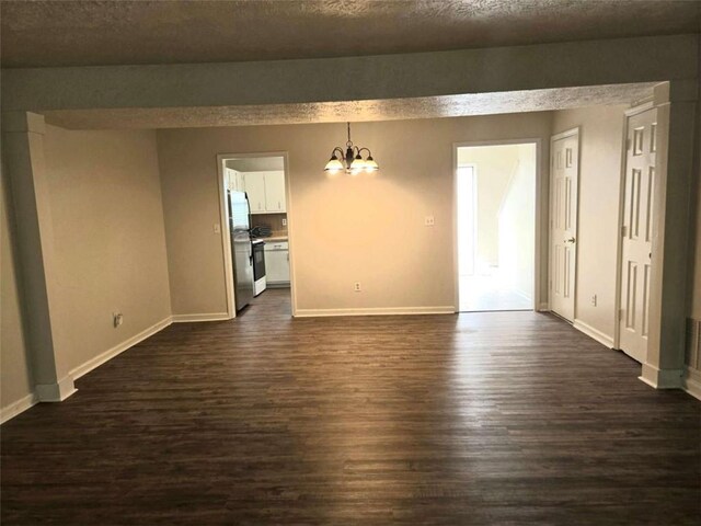 unfurnished dining area with a chandelier, dark wood-style floors, and baseboards