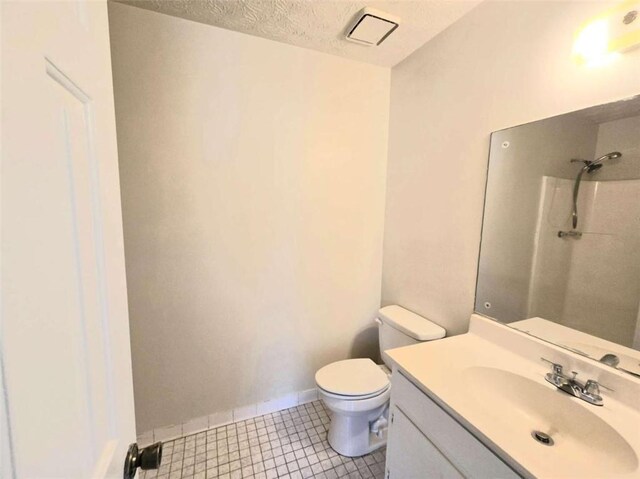 full bathroom with toilet, vanity, a shower, a textured ceiling, and baseboards
