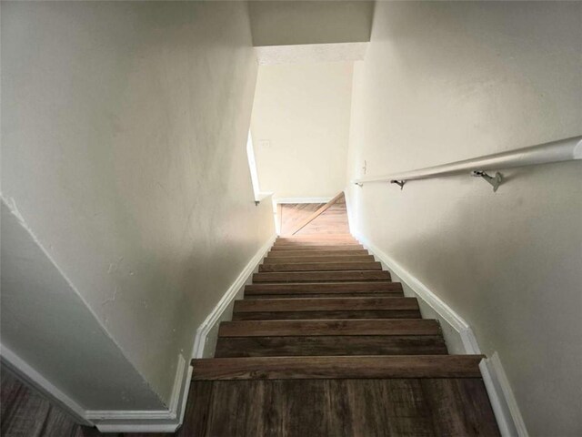 stairs with wood finished floors and baseboards