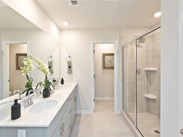 bathroom with double vanity, a stall shower, a sink, and visible vents