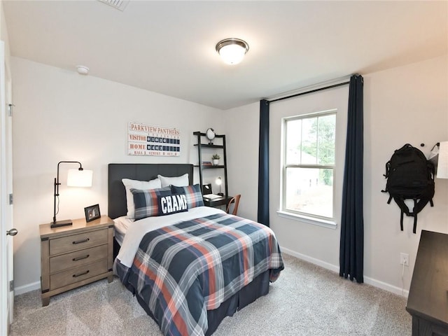 bedroom with light carpet and baseboards