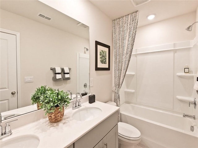 full bathroom featuring visible vents, a sink, toilet, and double vanity