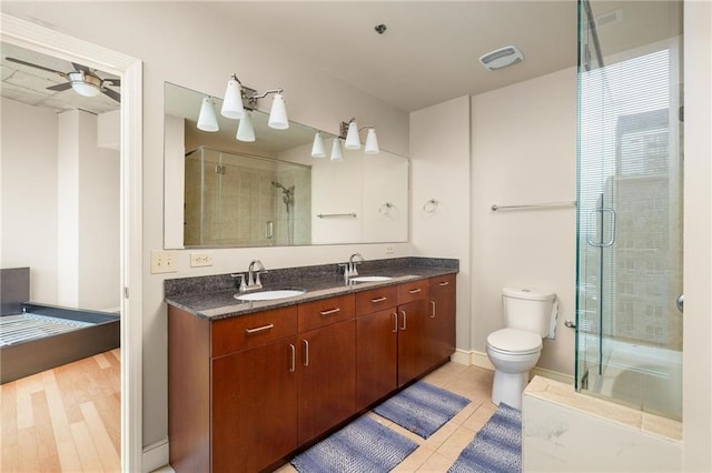 44 Peachtree Pl NE Unit 1824, Atlanta, GA 30309 - bathroom featuring a shower with door, double vanity, ceiling fan, toilet, and tile patterned floors