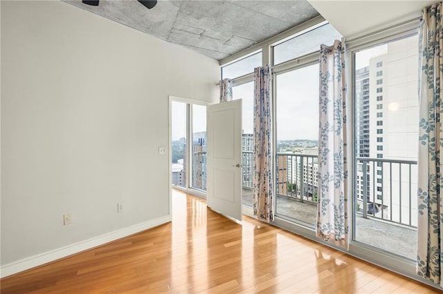 44 Peachtree Pl NE Unit 1824, Atlanta, GA 30309 - spare room with wood finished floors, healthy amount of natural light, baseboards, floor to ceiling windows, and ceiling fan