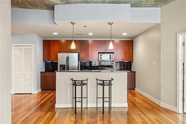 44 Peachtree Pl NE Unit 1824, Atlanta, GA 30309 - kitchen featuring appliances with stainless steel finishes, light wood-style flooring, tasteful backsplash, and recessed lighting