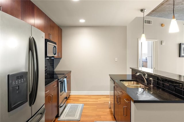 44 Peachtree Pl NE Unit 1824, Atlanta, GA 30309 - kitchen with stainless steel appliances, a sink, dark countertops, light wood-style flooring, and baseboards