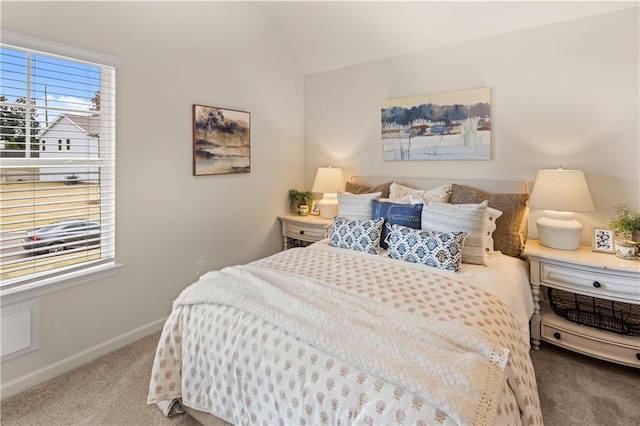 bedroom featuring light carpet, vaulted ceiling, and baseboards