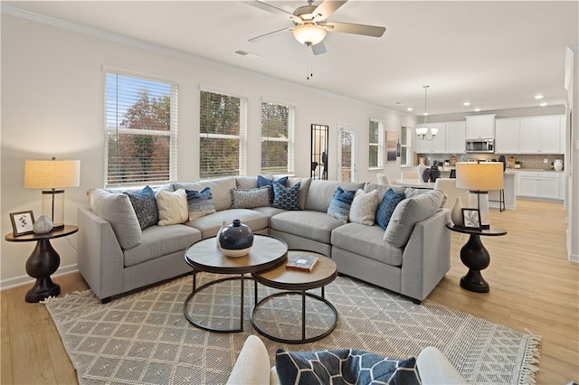 living room with ornamental molding, recessed lighting, visible vents, and light wood-style flooring