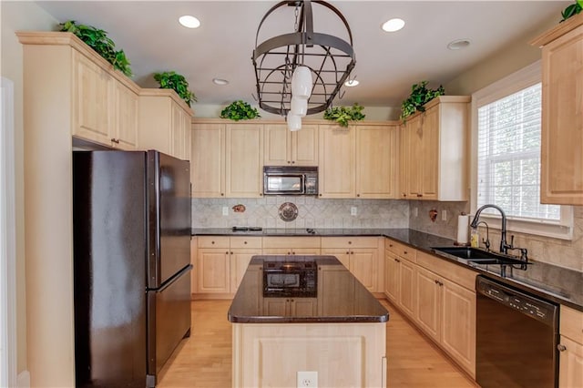 kitchen featuring black appliances, a center island, sink, and light brown cabinets