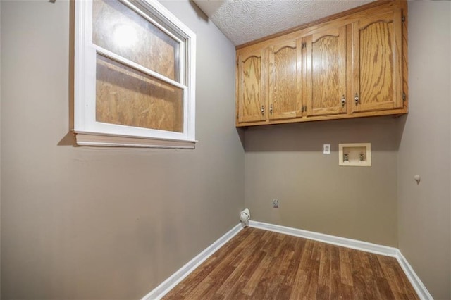 clothes washing area with washer hookup, cabinet space, dark wood finished floors, and baseboards