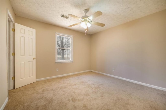 spare room featuring a ceiling fan, baseboards, visible vents, and carpet flooring