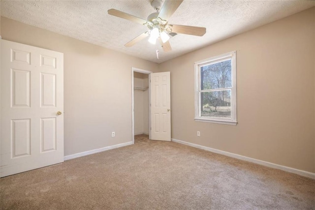 unfurnished bedroom with a textured ceiling, carpet, and baseboards