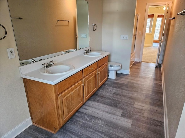 full bathroom with wood finished floors, a sink, and toilet