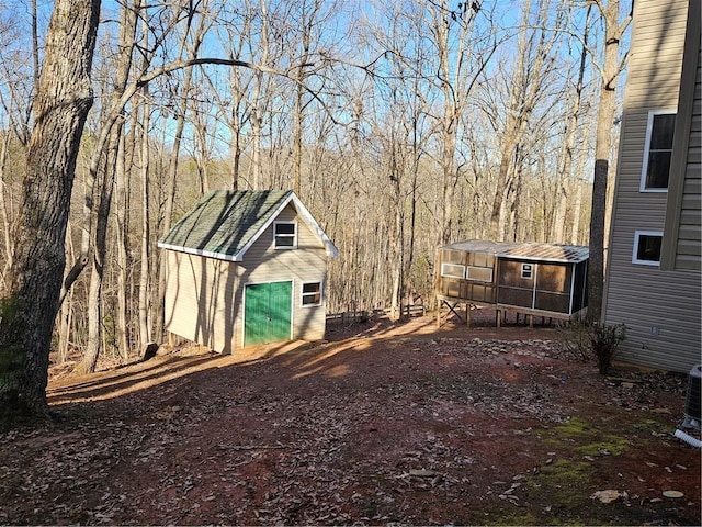 view of yard featuring an outdoor structure and a forest view