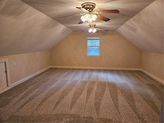 additional living space featuring carpet floors, a ceiling fan, vaulted ceiling, a textured ceiling, and baseboards