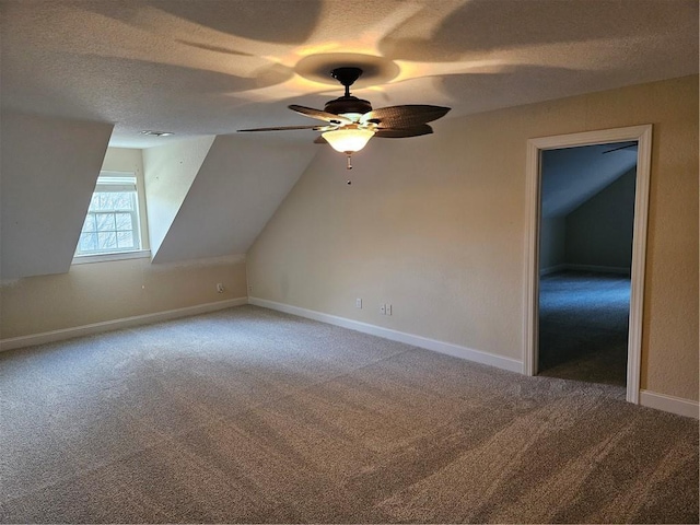 bonus room with carpet flooring, vaulted ceiling, a textured ceiling, and baseboards