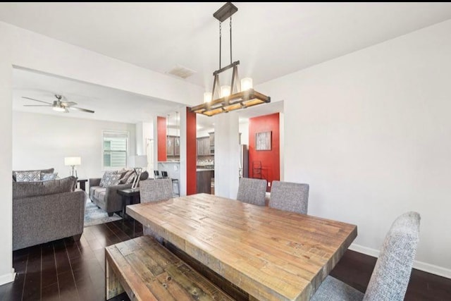 dining room featuring dark hardwood / wood-style floors and ceiling fan with notable chandelier