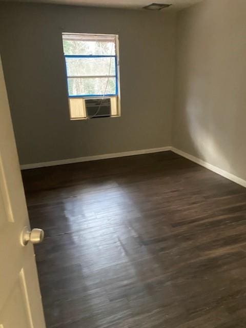 unfurnished room featuring dark wood-type flooring, cooling unit, and baseboards