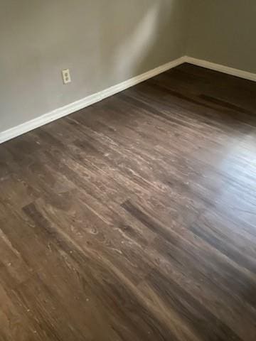 interior space featuring baseboards and dark wood-type flooring