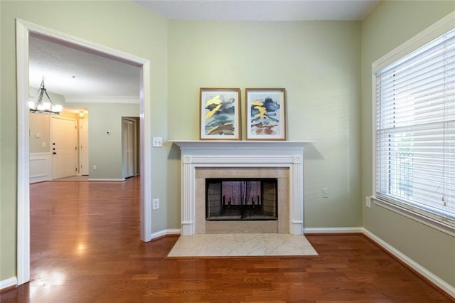 unfurnished living room featuring a fireplace, baseboards, and wood finished floors