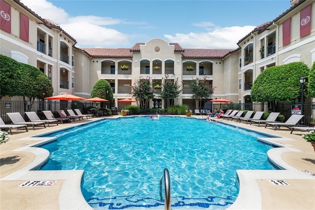 pool with a patio area and fence