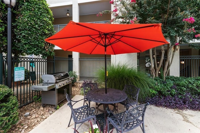 view of patio featuring outdoor dining space, area for grilling, and fence