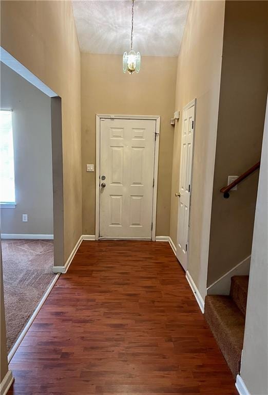 entrance foyer featuring a towering ceiling, a notable chandelier, and dark hardwood / wood-style flooring