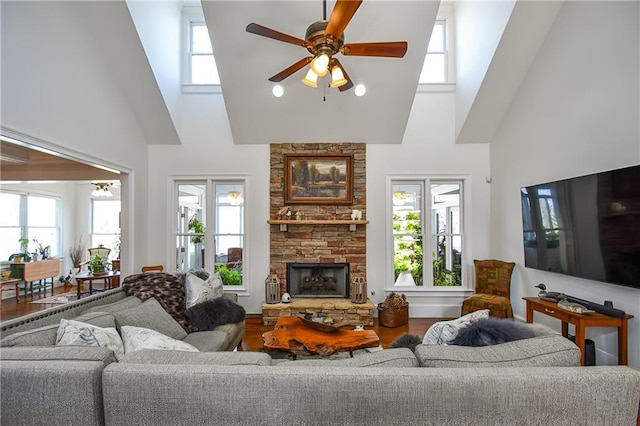 living area featuring a fireplace, high vaulted ceiling, wood finished floors, and ceiling fan