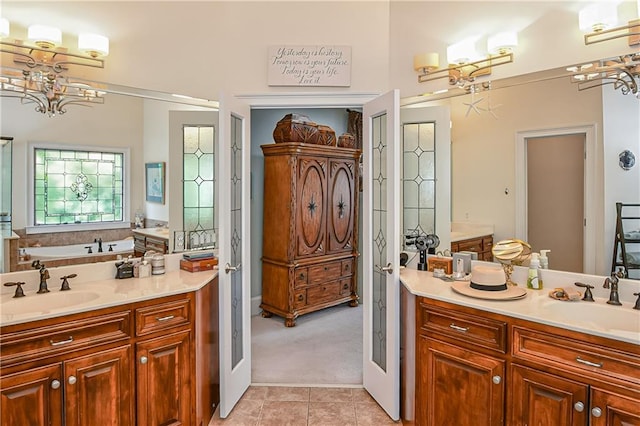 full bath with tile patterned flooring, two vanities, french doors, and a sink