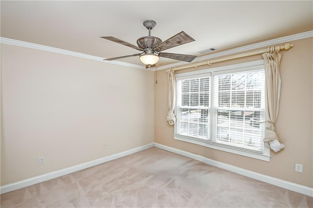 spare room featuring light carpet, crown molding, baseboards, a ceiling fan, and visible vents